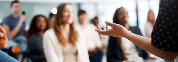 A trainer presenting to a trainees who are listening intently.