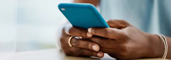 A person typing a message their phone on a live chat.