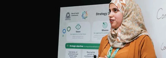 A women confidently speaking in a meeting.