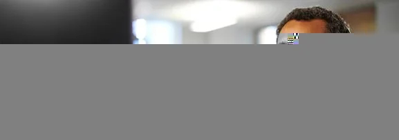 A counsellor on a support call, through a headset whilst taking notes on a computer.